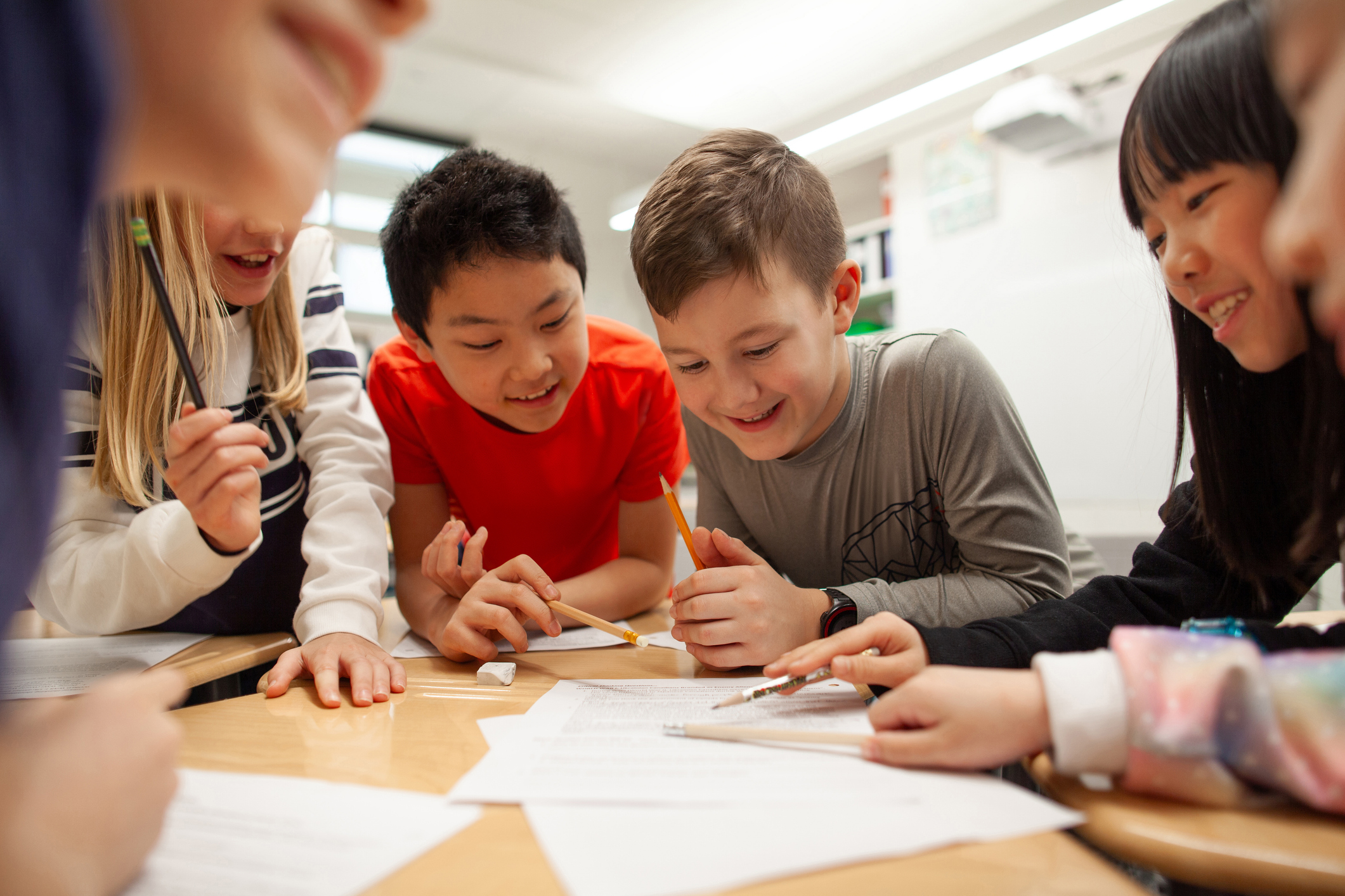 Children collaborating enthusiastically on a group project at a classroom table
