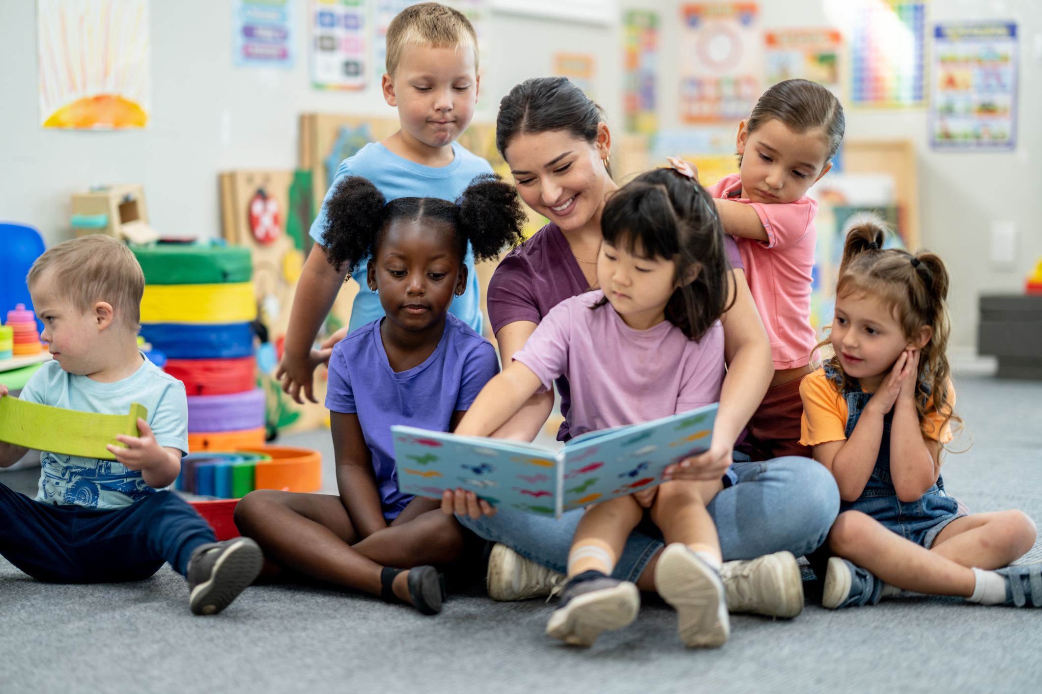 Children and teacher reading together in a colorful classroom setting