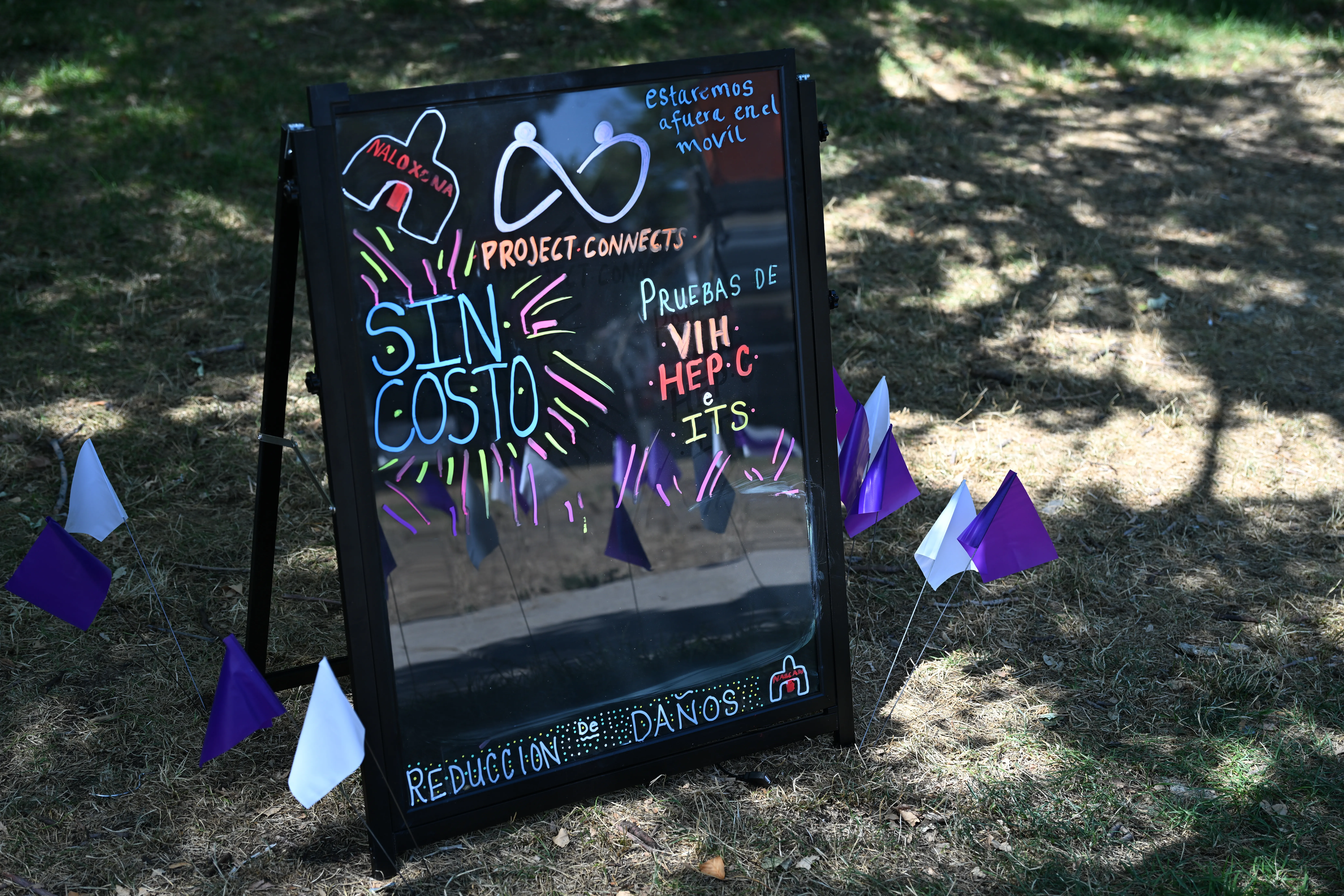 Photo of a display board showing services for Sexual Health and Harm Reduction program