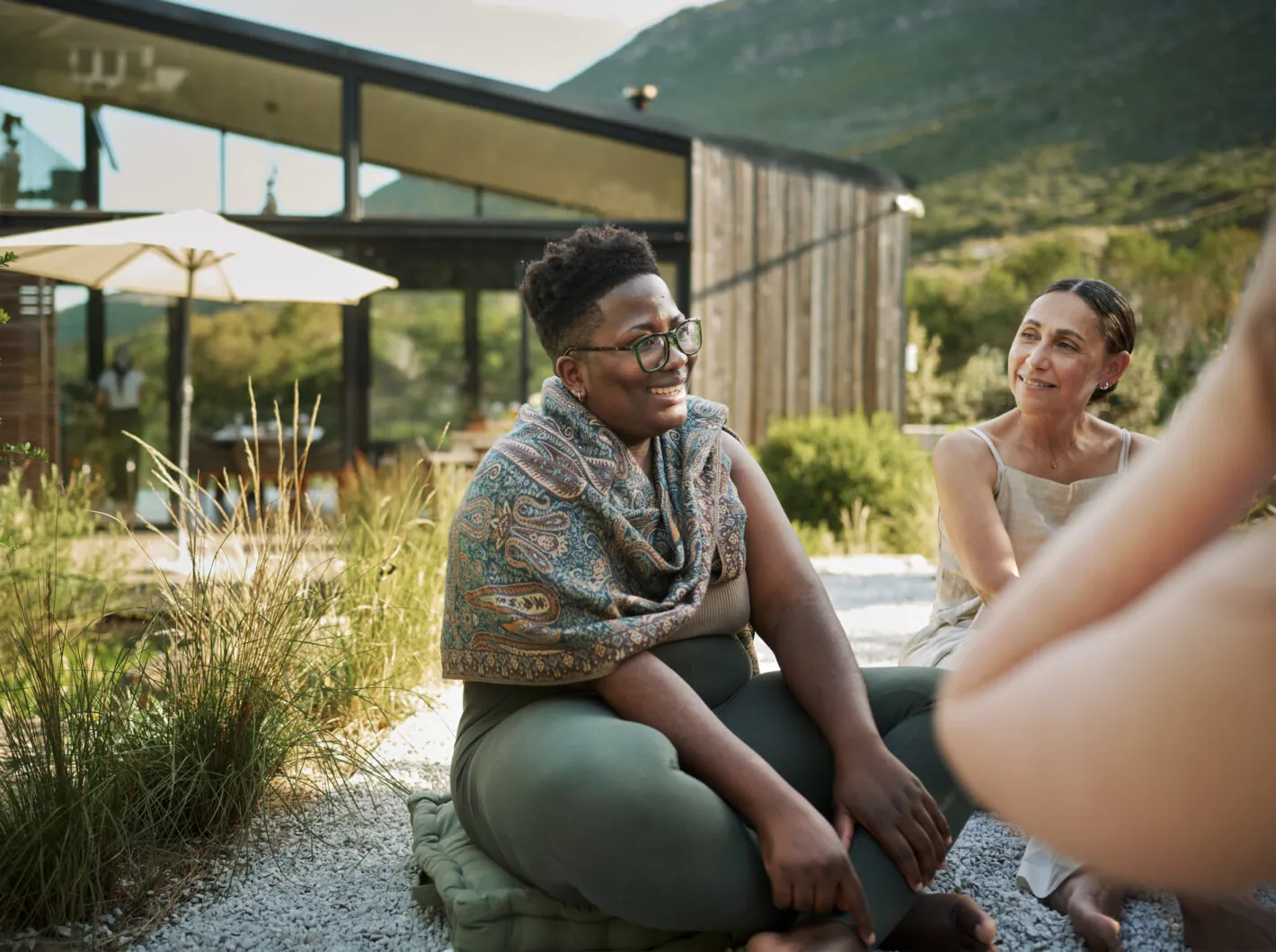 Photo of a group of people smiling while sitting outdoors