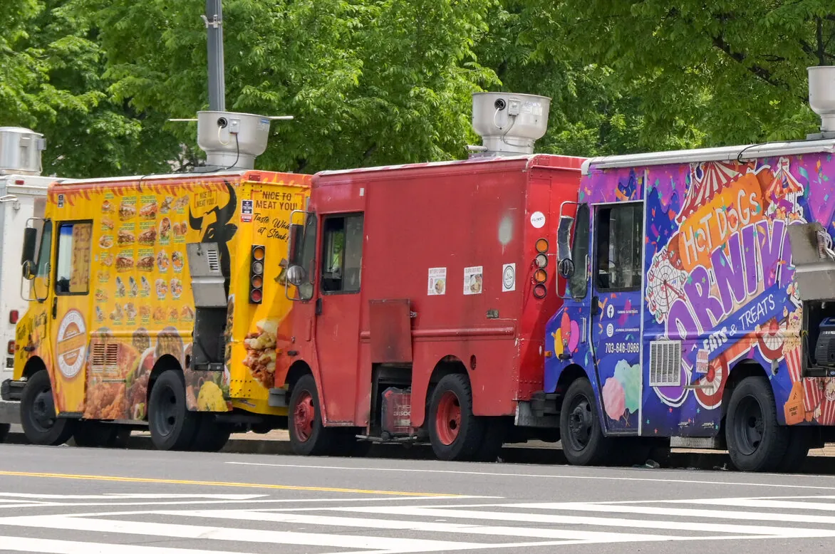 Photo of food trucks lined up on the site of the road