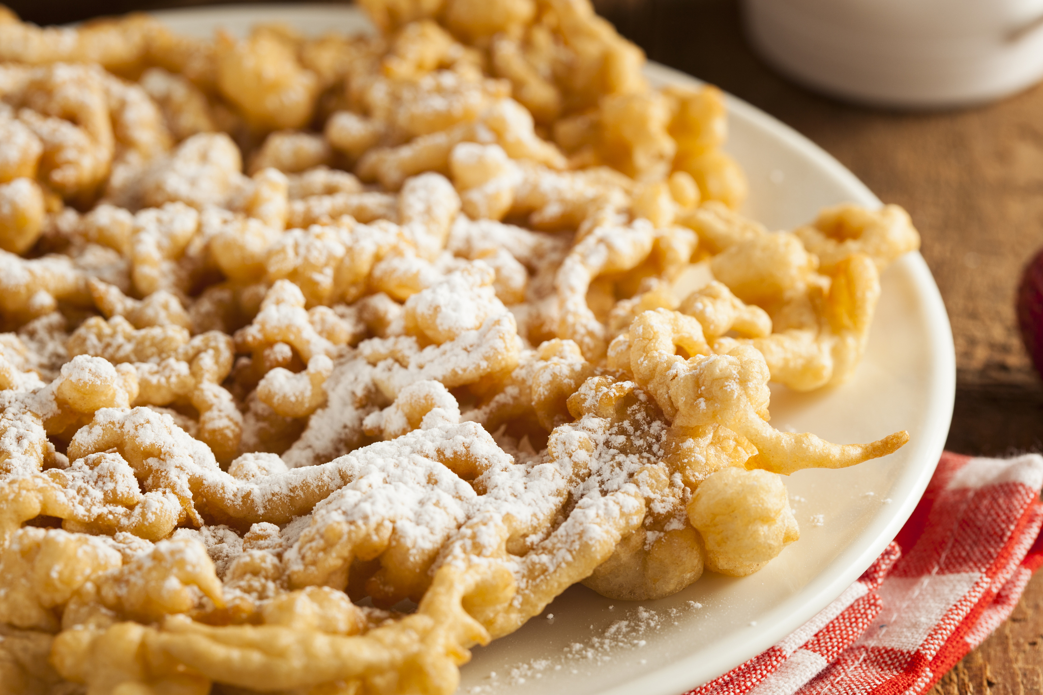 Close up photo of a funnel cake with powdered sugar on top