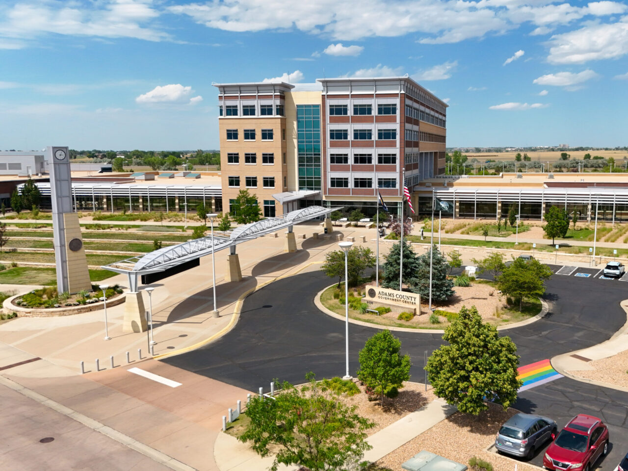Adams County Government Center with clock tower, circular driveway, and visible rainbow crosswalk