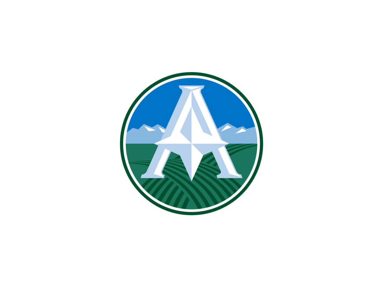 Large white letter "A" over fields with mountains